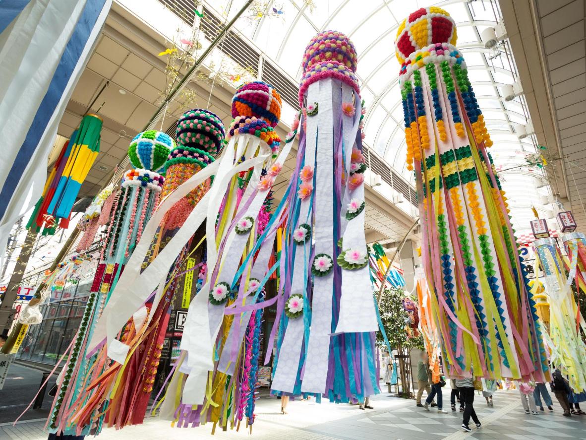 Walk streets lined with colorful decorations, streamers, and paper crafts. Photo credit: © 仙台七夕まつり協賛会