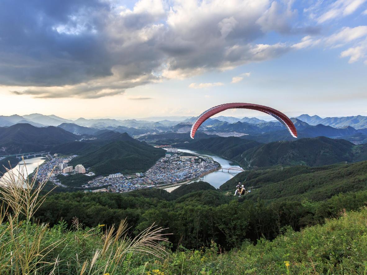 Soar over mountains and follow the Namhan River while paragliding in Danyang