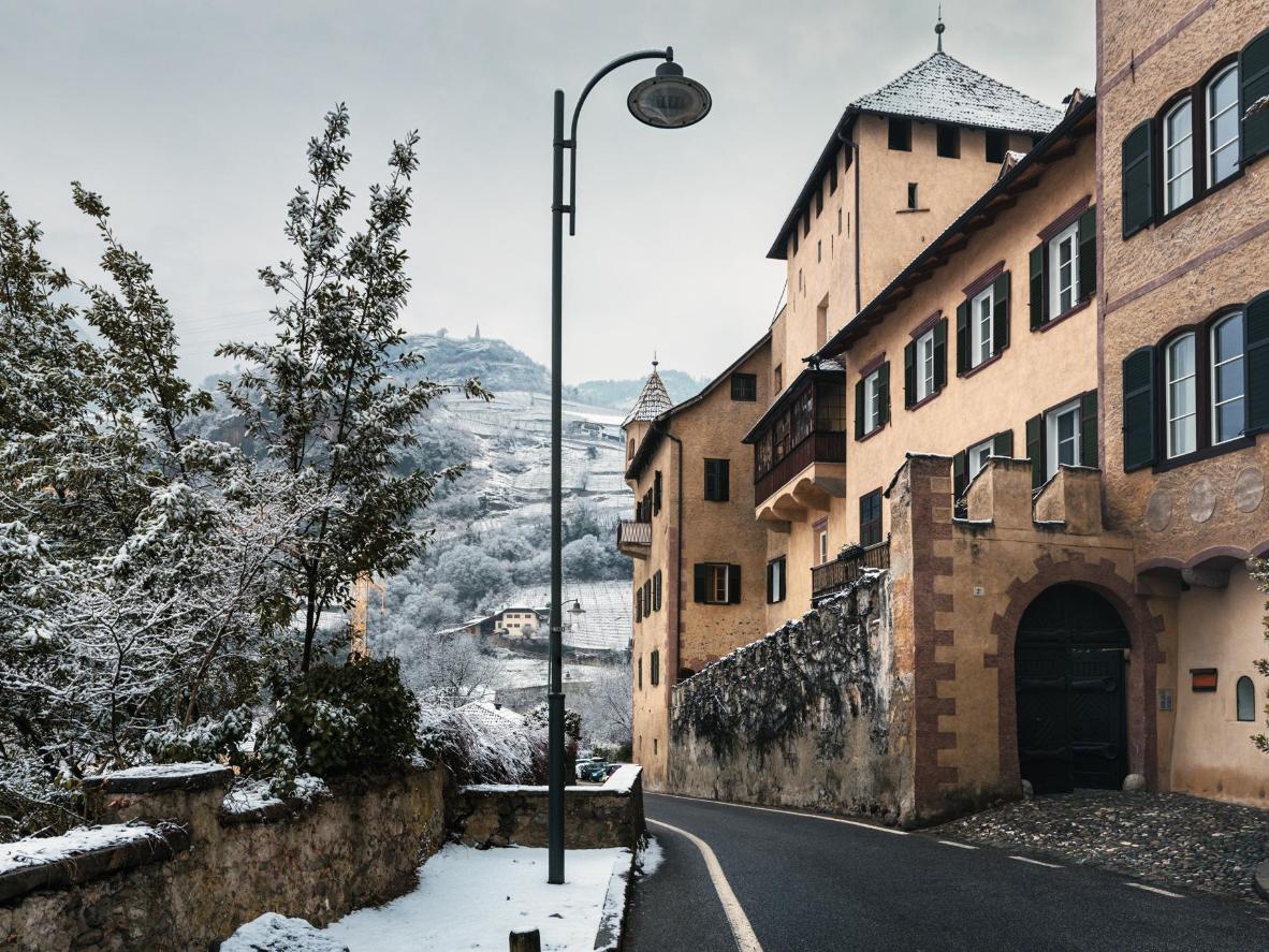 이탈리아 볼차노의 눈 덮인 산을 배경으로 자리 잡은 로마풍 건축물