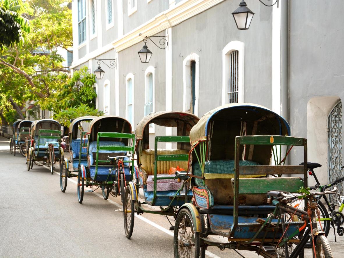 Cycle rickshaws parked in the leafy streets of Pondicherry, India