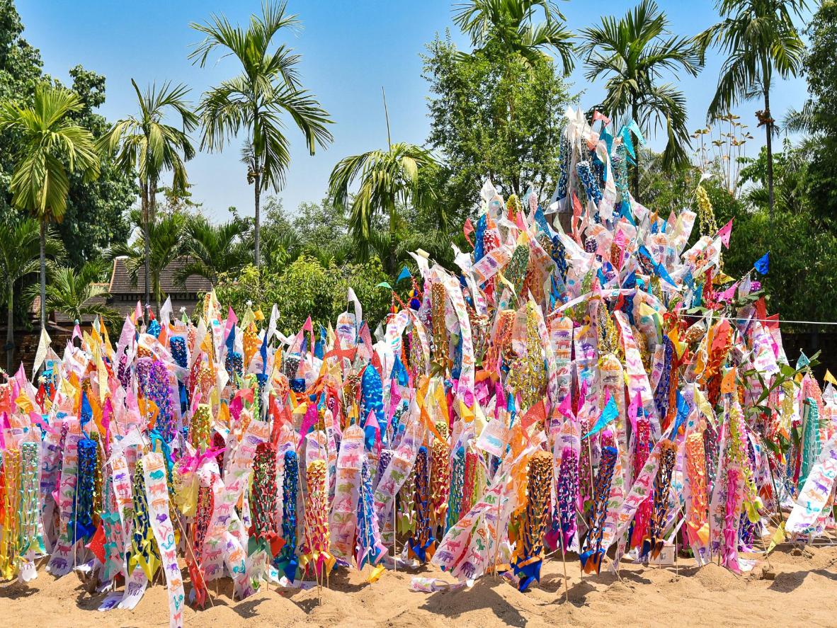 Des drapeaux en papier décorent des pagodes de sable lors du Songkran