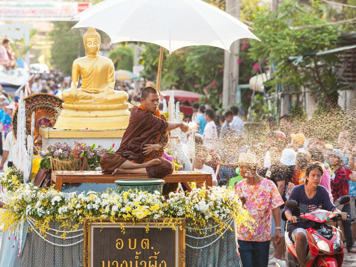 Un moine bouddhiste diffuse de l’eau bénite pendant le festival de Songkran