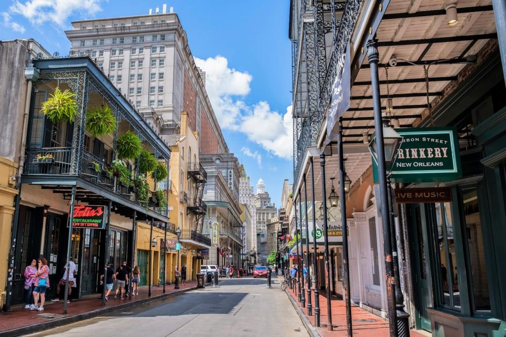 A bustling Bourbon Street scene with people walking along the street, surrounded by historic buildings