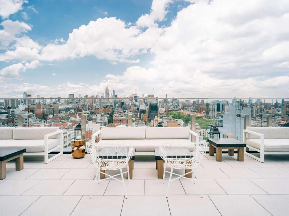 Rooftop terrace at the The Crown in New York, featuring city skyline views and outdoor seating arrangements
