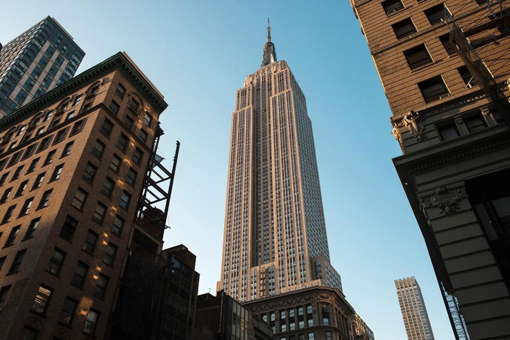 The Empire State Building towers in the background against a clear blue sky