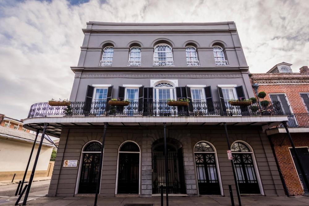 A historic building in New Orleans, featuring a balcony with a decorative railing, part of a ghost tour attraction
