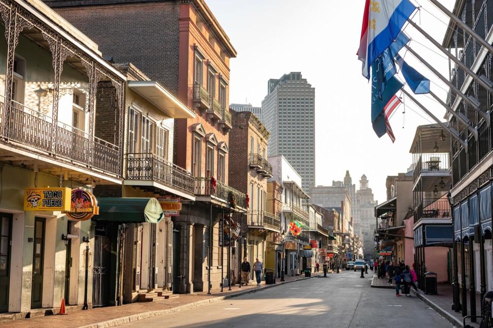 A bustling Bourbon Street scene with people walking along the street, surrounded by historic buildings