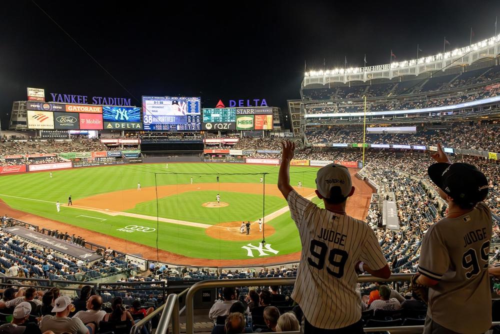An exciting baseball game at the Yankee Stadium, with players on the field and enthusiastic fans filling the stands