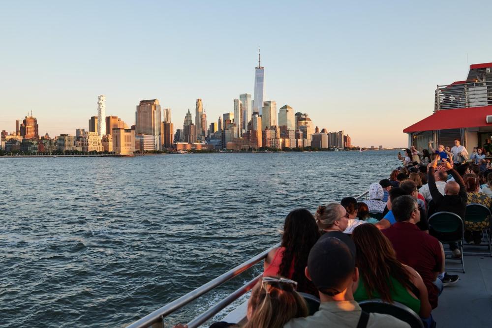 A group of people sit on a ferry in NYC, taking in the landscapes of the city