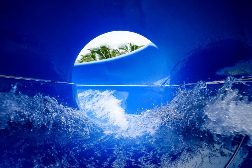 A blue water slide with a wave cascading from its top, inviting thrill-seekers to enjoy a fun ride