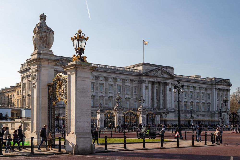 Buckingham Palace stands prominently, featuring a statue in front that adds to its grandeur.