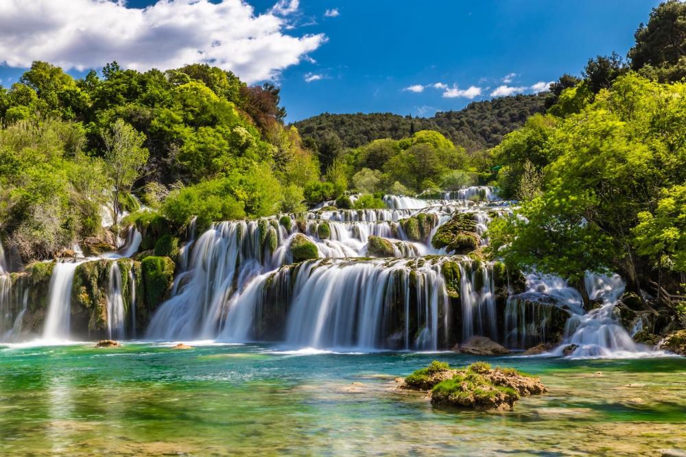 A stunning view of Skradinski Buk Waterfall in Croatia, showcasing cascading water amidst greenery.