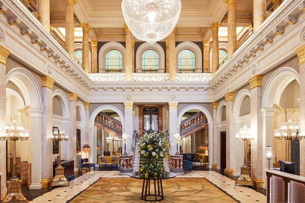 The elegant lobby of The Clermont London, featuring a chandelier that enhances the atmosphere.