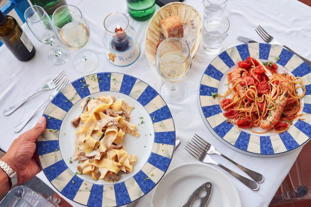 Two pasta dishes feature. One in a tomato sauce with prawns, the other with a thicker pasta with a creamy sauce