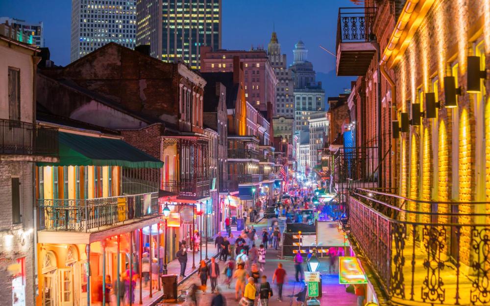 The streets of New Orleans look electric, with vibrant, neon lights and bustling streets