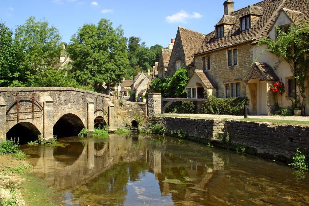A quaint bridge and charming houses with a lake flowing underneath 