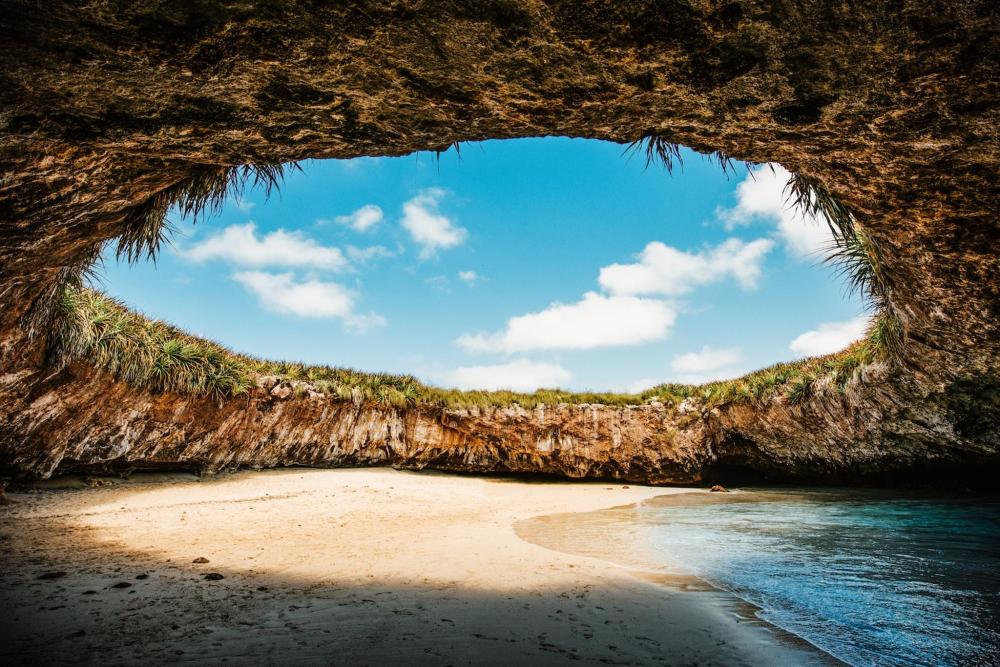 The serene cave of a beach in Puerto Vallarta under a clear blue sky, showcasing the natural beauty of coastal landscapes.