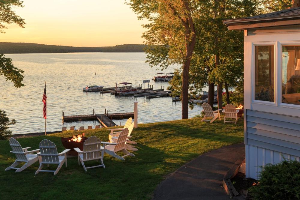 Tranquil Poconos lake featuring a picturesque house on its banks, framed by vibrant natural scenery.
