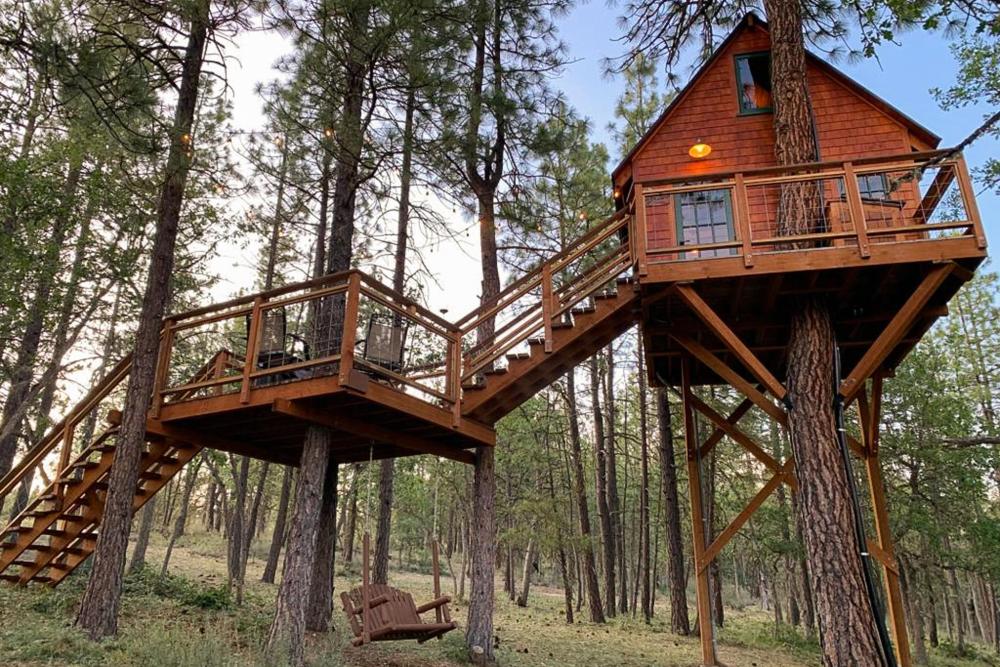 A tree house nestled in the woods of Treehouse Ranch, Washington, featuring a set of inviting stairs.