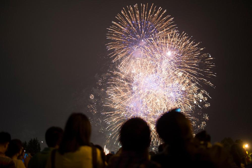 A diverse group of individuals enjoying a vibrant fireworks display during Bonfire Night festivities