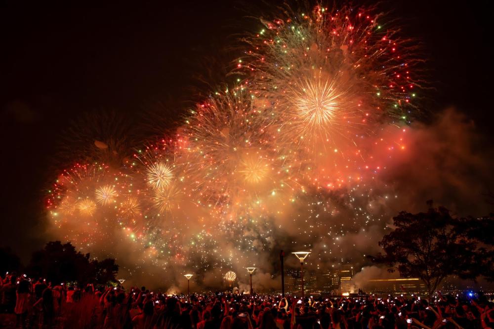 Colorful fireworks illuminate the night sky, creating a vibrant display of light and color against the dark backdrop.