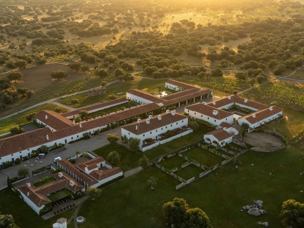 Aerial view of a large estate featuring a spacious courtyard and vineyards in São Lourenço do Barrocal.
