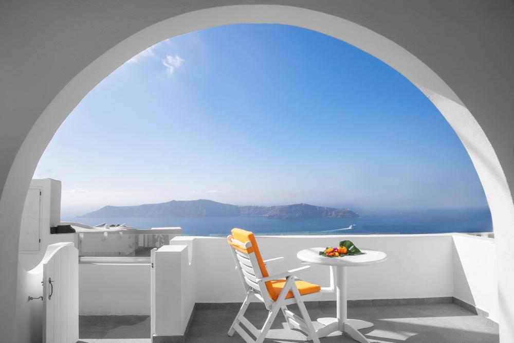 A picturesque view of the sea framed by an archway at Abelonas Retreat in Imerovigli, Greece.