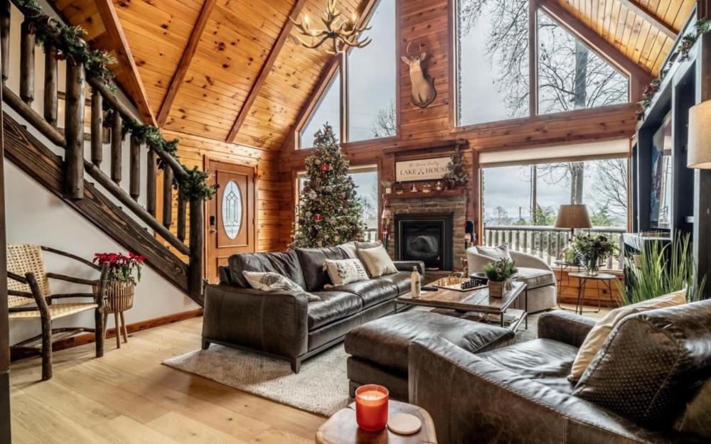 Rustic living room at Minnies Mountain Lakehouse, featuring a fireplace and warm wooden floors in La Follette, Tennessee.