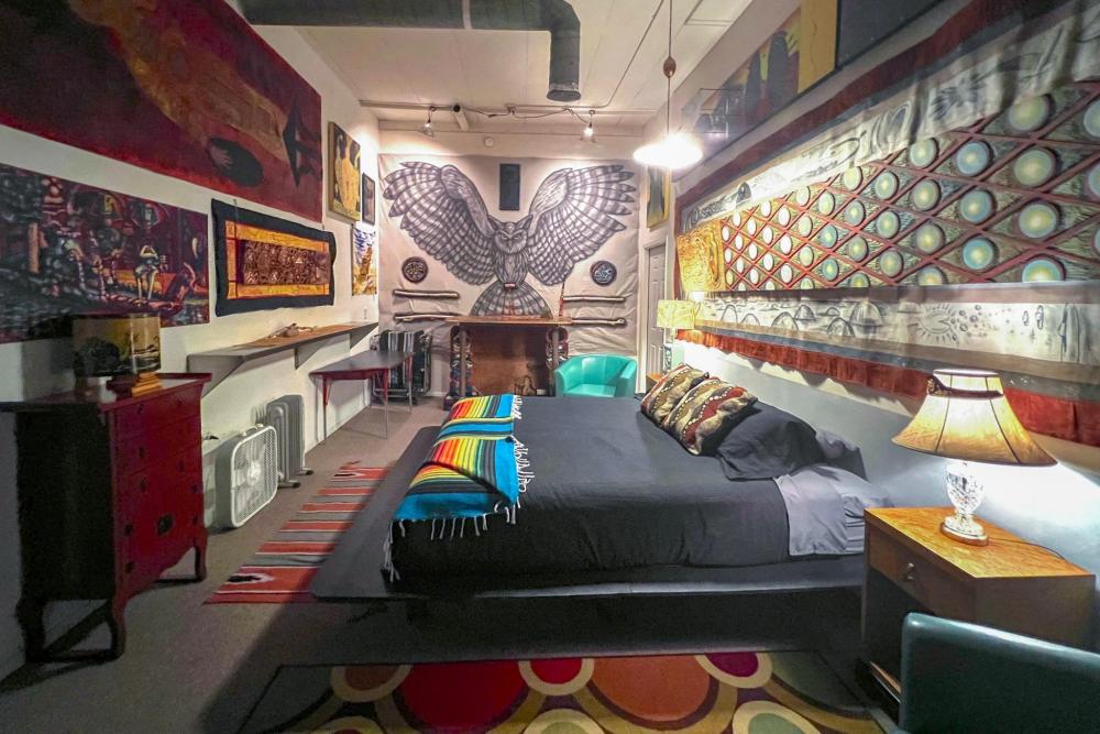 Cozy bedroom in Space Castle, Truth or Consequences, featuring a bed, lamp, and a stylish rug