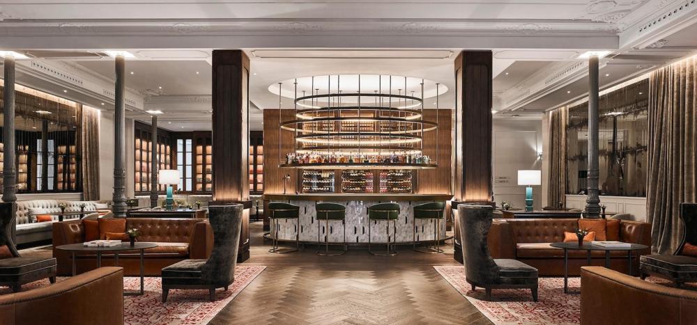 A luxurious hotel bar at Gran Hotel Inglés, adorned with plush leather seating and a well-stocked bar for guests.