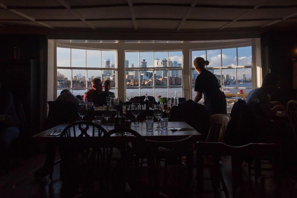 A large window in a London bar, showcasing the vibrant cityscape outside