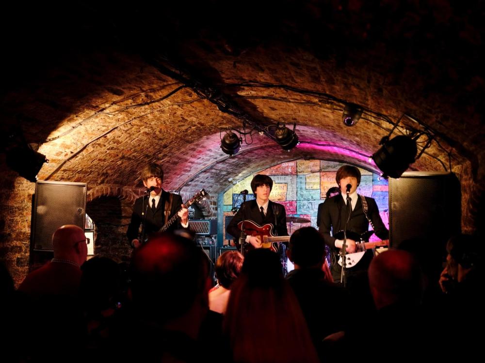 A Beatles tribute act play at The Cavern Club, the venue is bustling