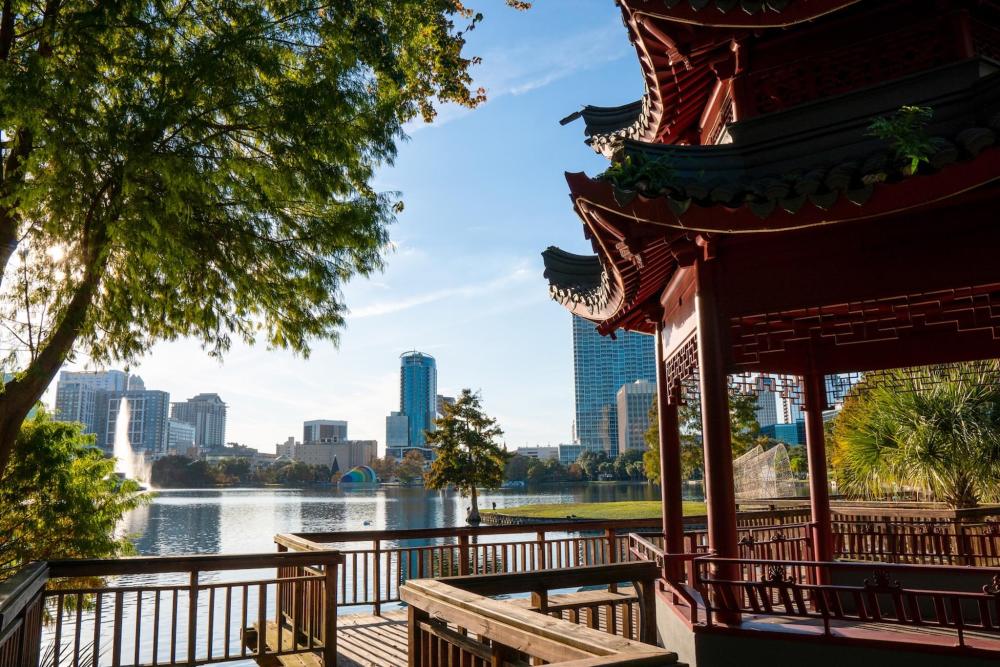 A pavilion overlooks the serene Lake Eola with the Downtown Orlando skyline in the background