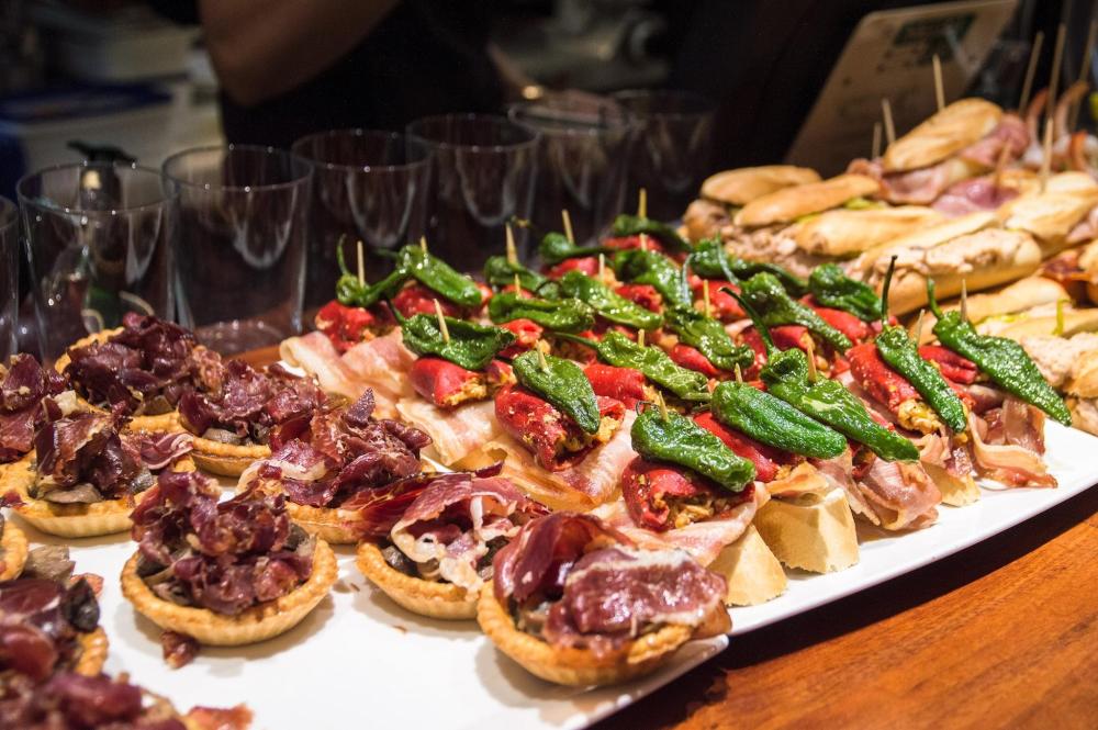 A buffet featuring an assortment of tapas, showcasing a selection of different types of meats