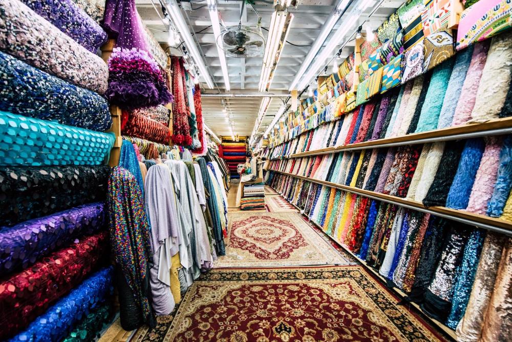 A vibrant store in the Garment District NYC showcasing an array of colourful fabrics and rugs.
