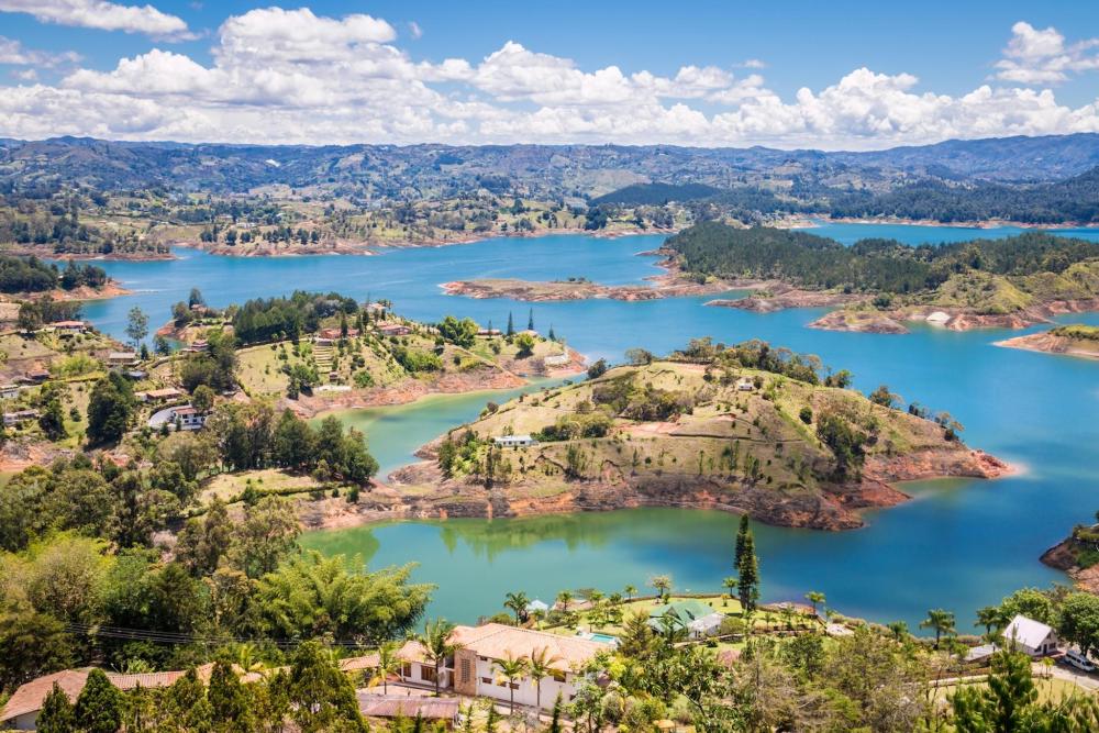 A serene lake nestled among hills and trees, showcasing the natural beauty of El Peñón