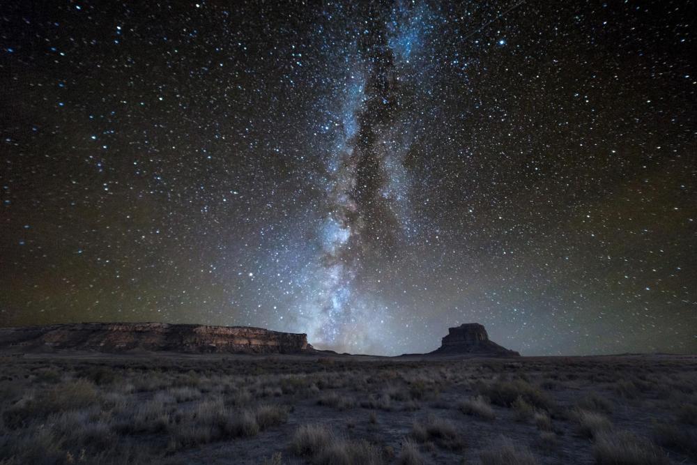 A celestial body stretches across the night sky above the desert landscape of Chaco Culture National Historical Park