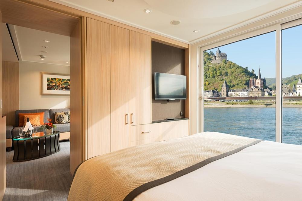 A bedroom featuring a scenic view of a river and mountains, part of a Viking River Cruise experience