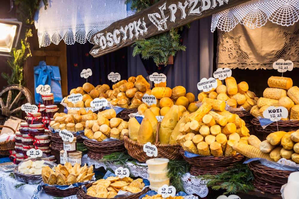 A beautifully arranged display of Oscypek cheese, showcasing its unique shape and texture, surrounded by fresh herbs