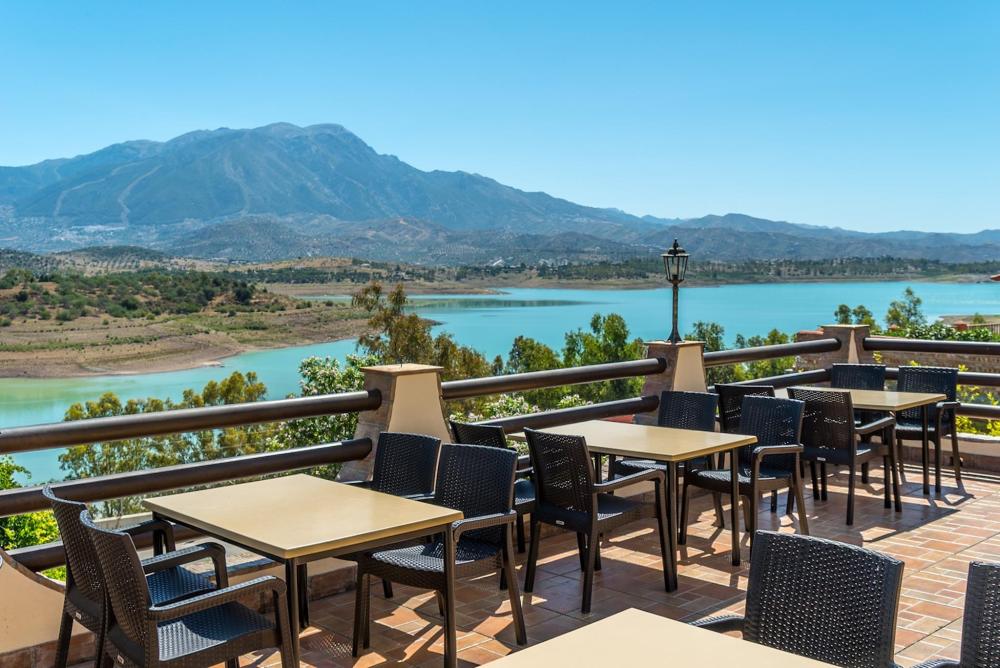 Tables and chairs are positioned to perfectly set the stage for guests to capture the view of the aquamarine body of water in the background