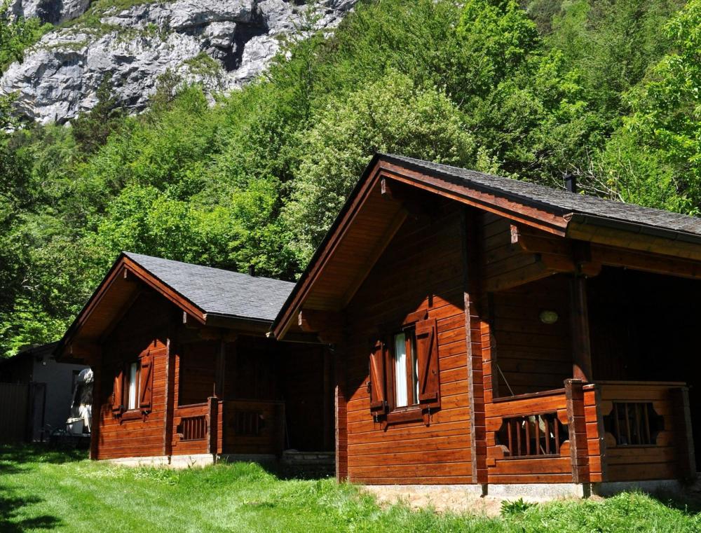 Some wooden cabins on a patch of grass at Camping Valle de Bujaruelo 