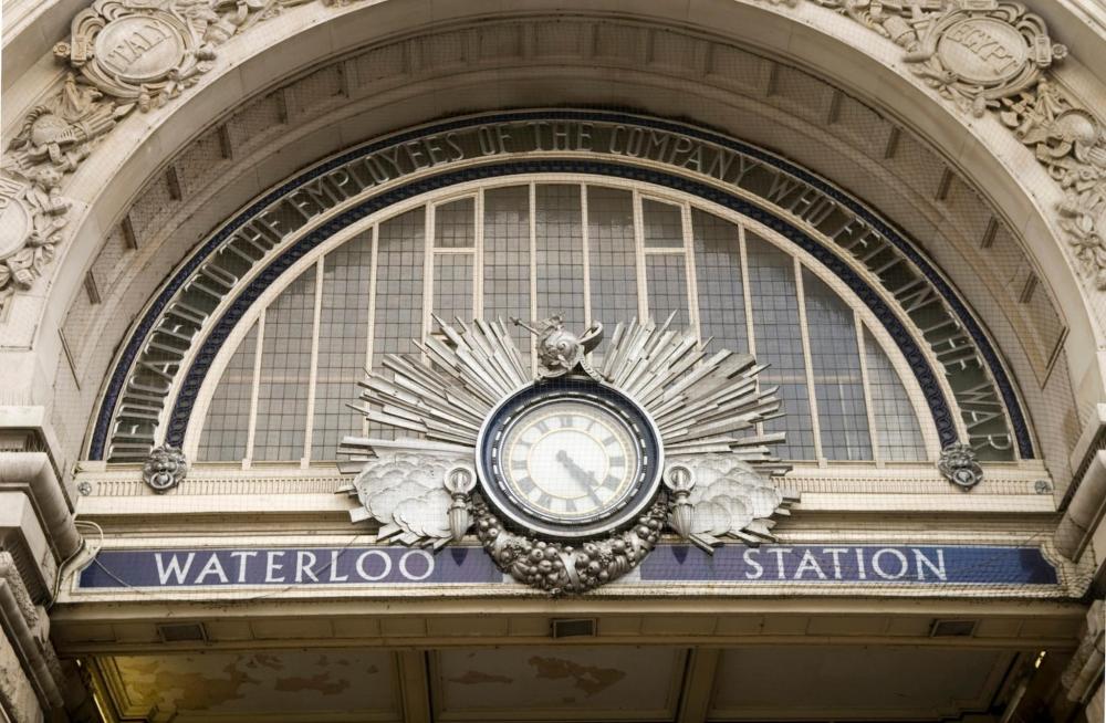 The outside Waterloo station is depicted with a clock above the sign