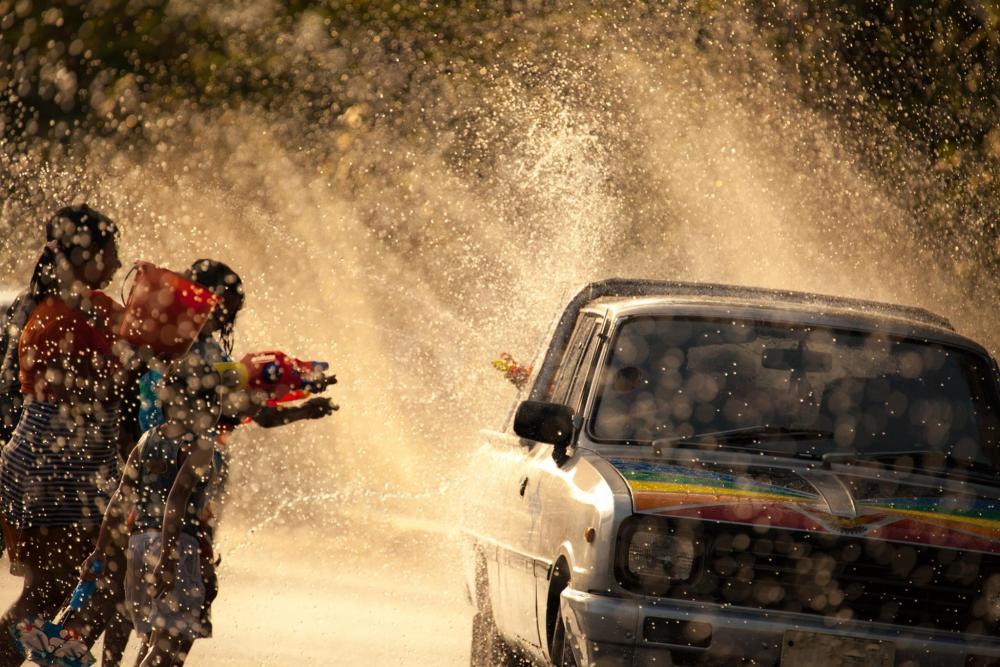 People use plastic water guns to splash each other during Songkran