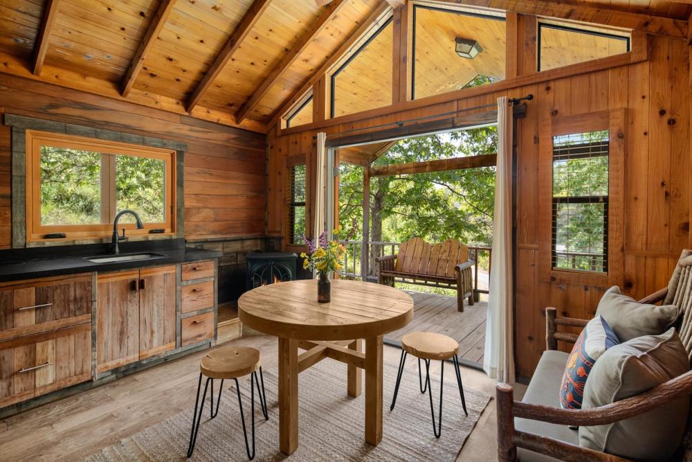 Cozy cabin kitchen and dining area in El Capitan Canyon, California, featuring rustic decor and warm, inviting ambiance.