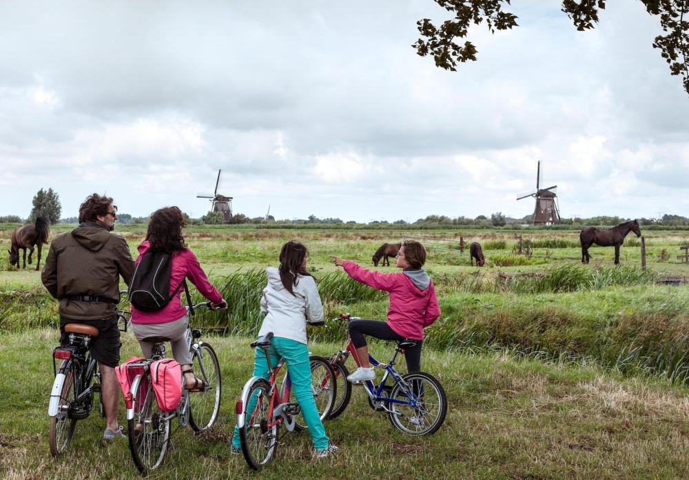 A family of rides bikes along the beach in Kijkduin, The Hague, enjoying a sunny day outdoors