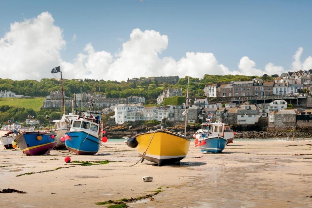 Colorful boats resting on the sandy beach at a sunny coastal getaway.