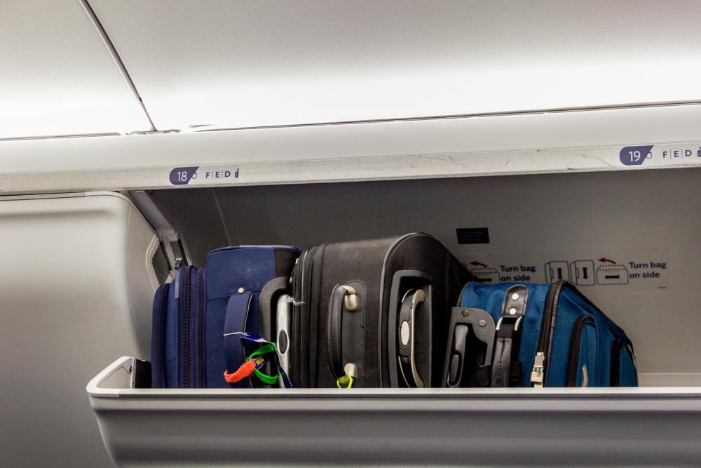 Luggage is stored neatly in the overhead luggage compartment