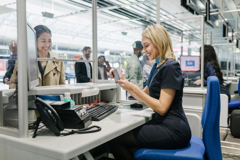 Airport check-in agent verifies passport for passenger