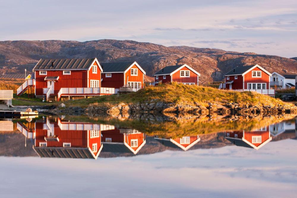 Traditional nordic houses set behind a scenic backdrop of mountains