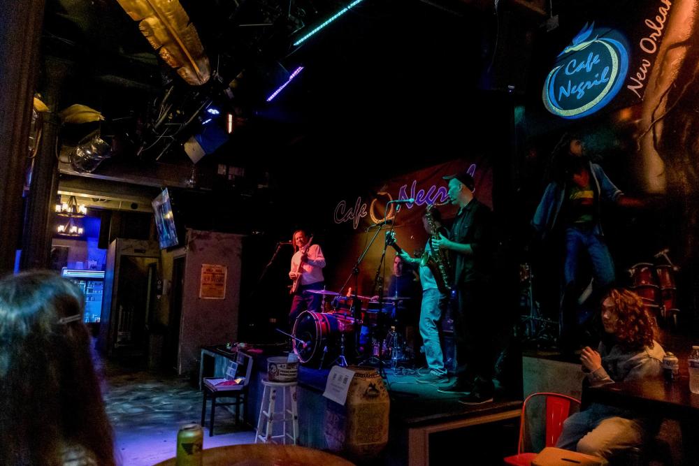 A jazz band play on a neon lit stage